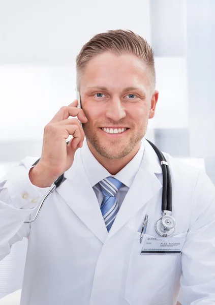 Дружелюбный доктор болтает по мобильному телефону — стоковое фото