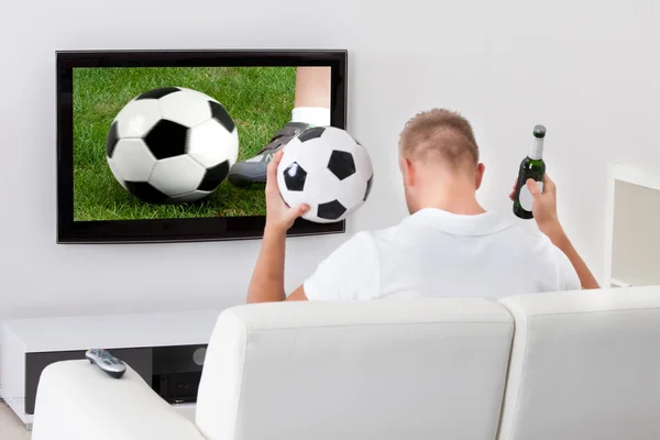 Excited soccer fan watching a game on television — Stock Photo, Image