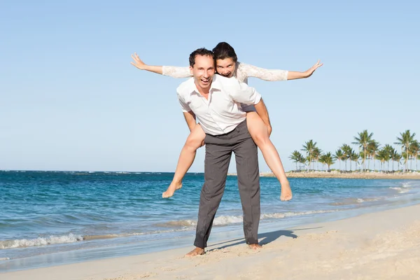 Mann gibt Frau am Strand Huckepack-Fahrt — Stockfoto