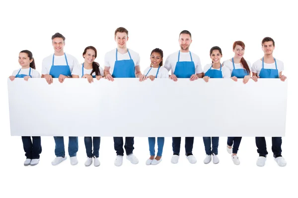 Group of cleaners holding a blank white banner — Stock Photo, Image