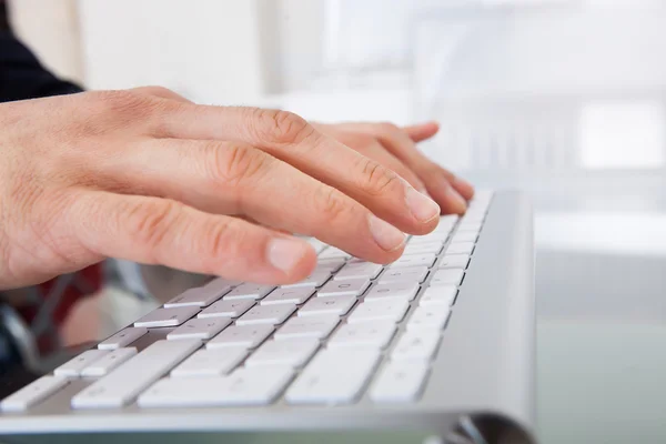 Empresario escribiendo en el teclado en el escritorio Fotos de stock libres de derechos