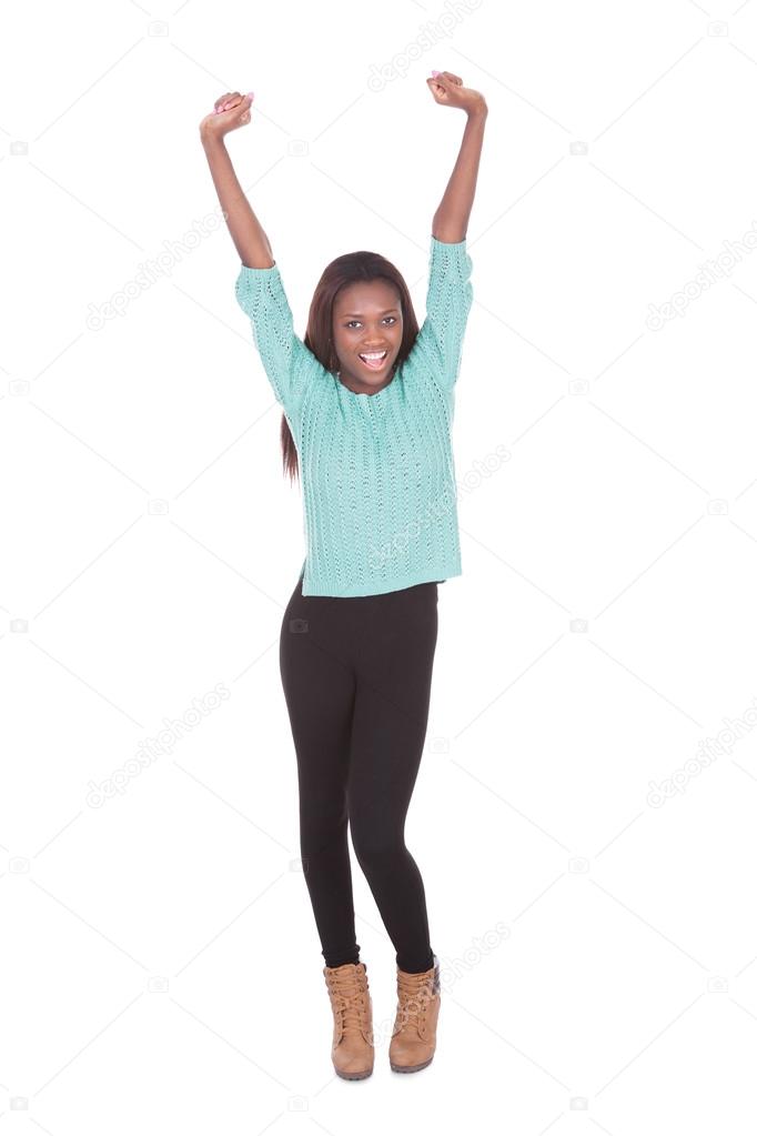 Excited young woman with arms raised