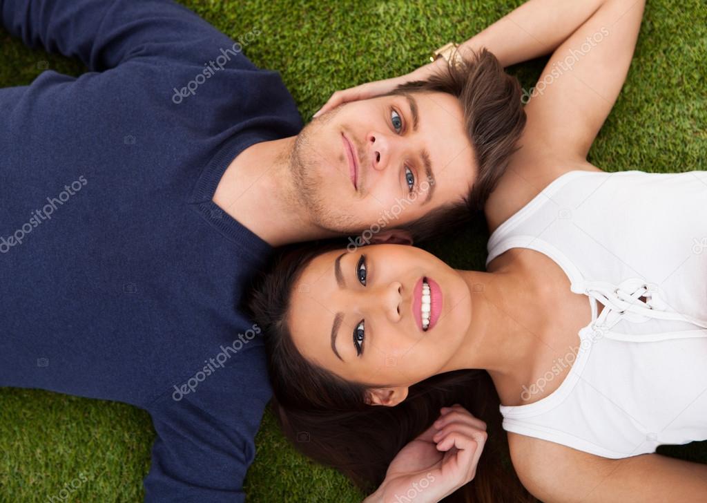 Young Couple Lying On Grass