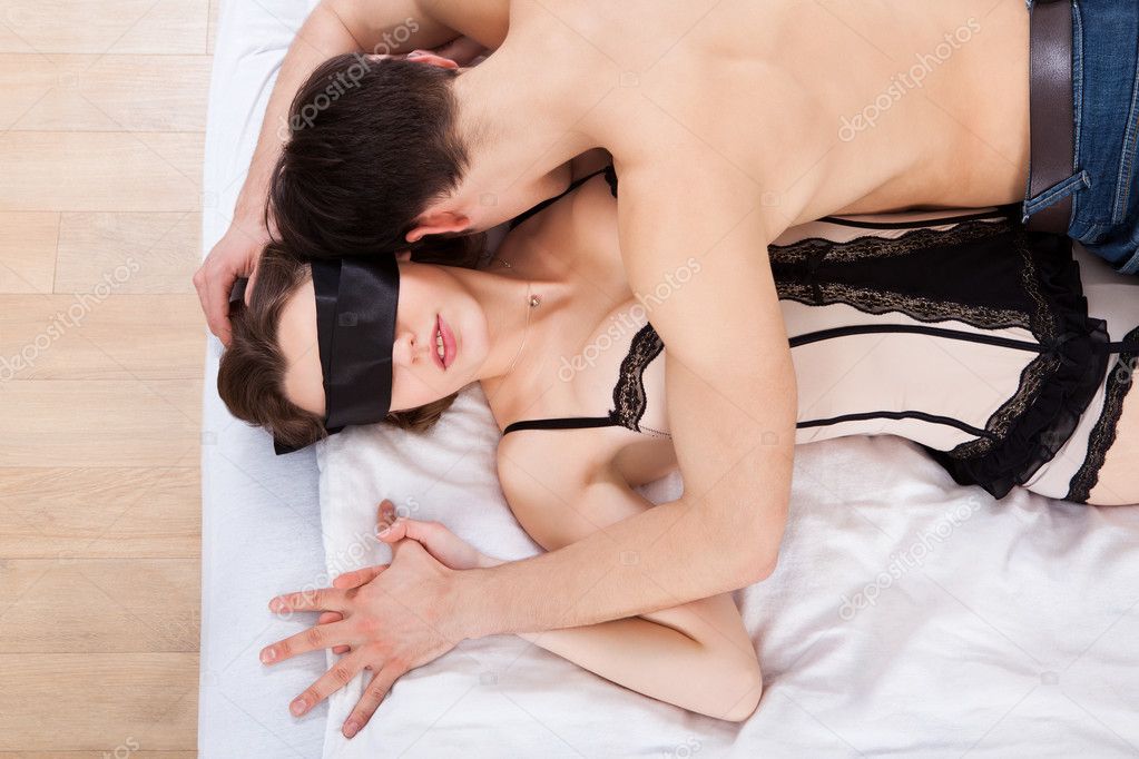 Man Kissing Sexy Blindfolded Woman In Bed