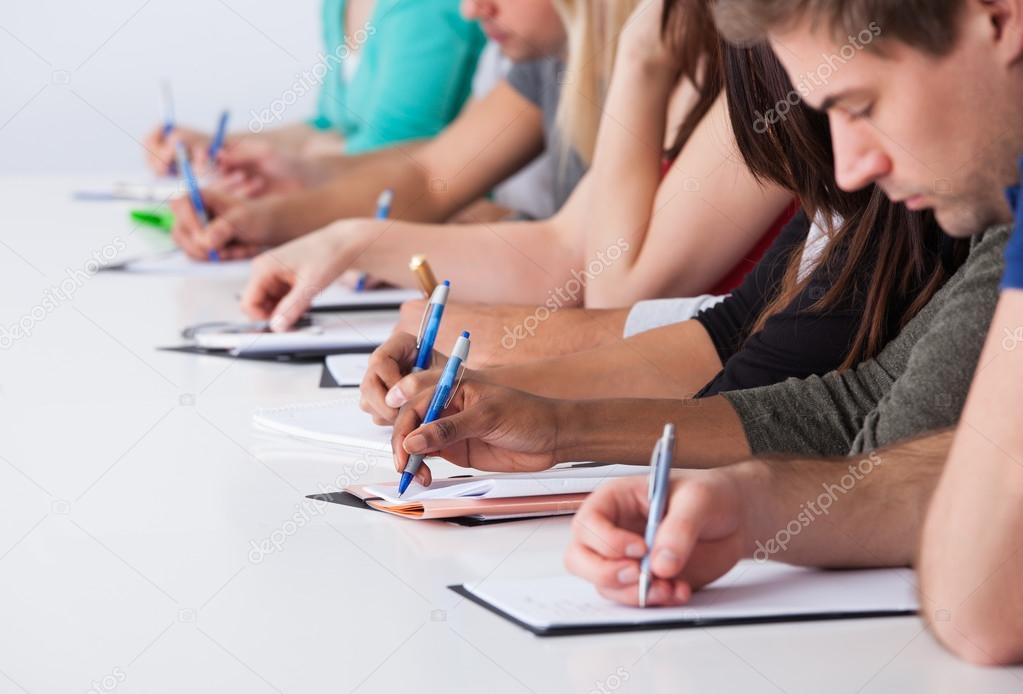 University Students Writing At Desk