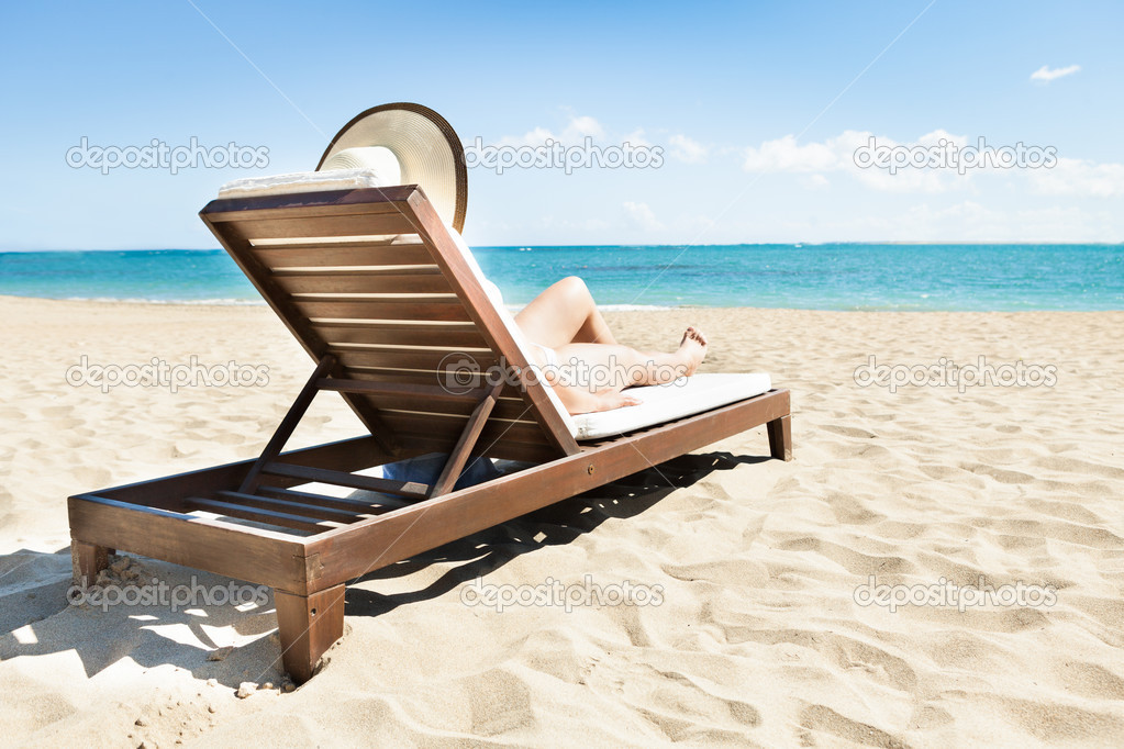 Woman Sunbathing On Deck Chair At Beach — Stock Photo © AndreyPopov