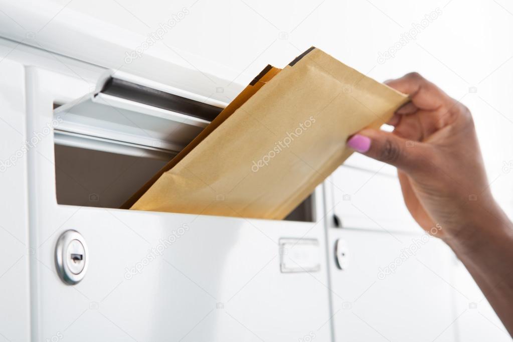 Woman Putting Letters In Mailbox