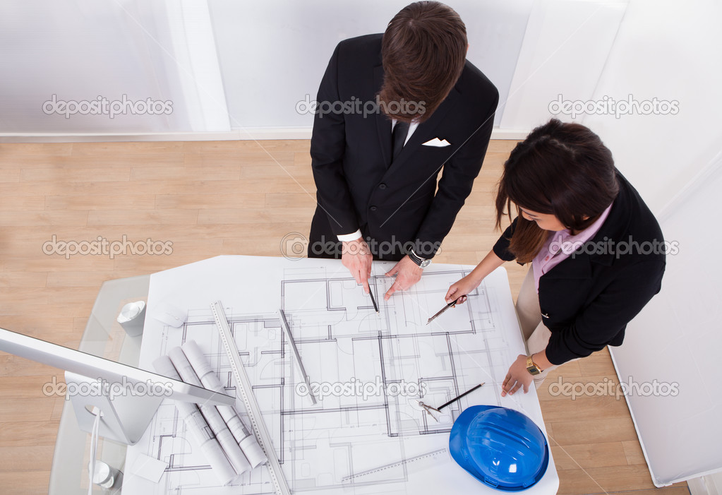 Architects Discussing Over Blueprint