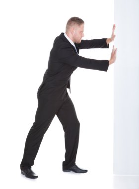 Businessman pushing the edge of a blank white sign