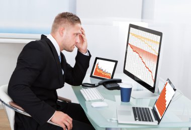 Despairing businessman faced with financial losses clipart