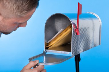 Man opening his mailbox to remove mail clipart