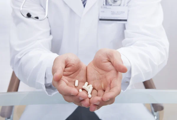 Arzt oder Krankenschwester im weißen Laborkittel mit Tabletten — Stockfoto