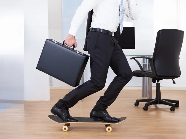 Geschäftsmann auf Skateboard im Amt — Stockfoto