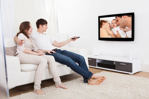 Pár, v obývacím pokoji, sledování televize — Stock fotografie