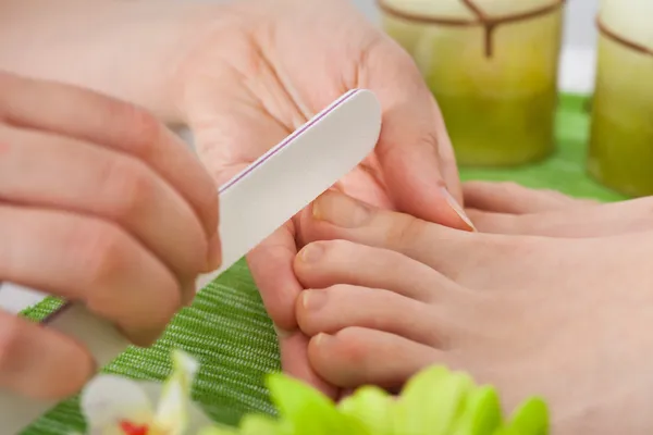 Esteticista arquivando unhas de mulher — Fotografia de Stock