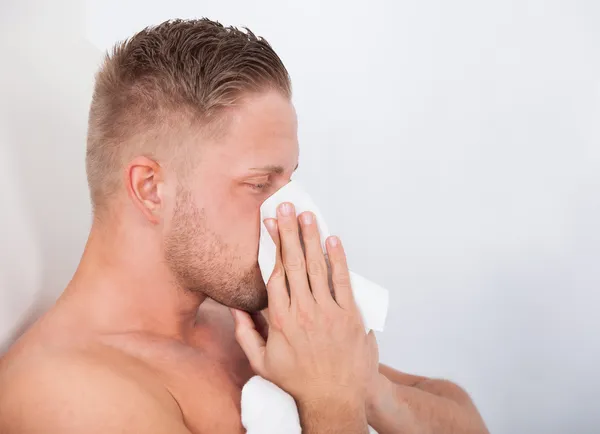Homem com um frio a assoar o nariz — Fotografia de Stock