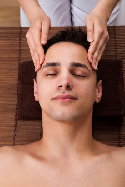 Mann erhält Kopfmassage von Massager im Wellnessbereich — Stockfoto