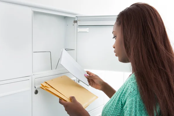 Жінка отримує листи з поштової скриньки — стокове фото