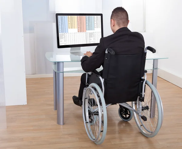 Zakenman op rolstoel met behulp van computer — Stockfoto