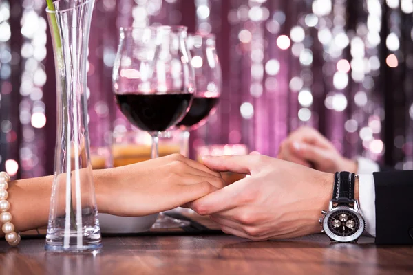 Paar hält sich beim Abendessen die Hand — Stockfoto