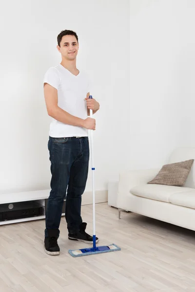 Hombre joven Mopping piso en casa —  Fotos de Stock