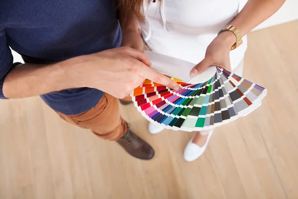 Pareja que elige el color para la pared en el nuevo hogar — Foto de Stock