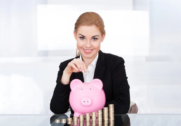 Mulher de negócios Inserindo Moeda Em Piggybank — Fotografia de Stock