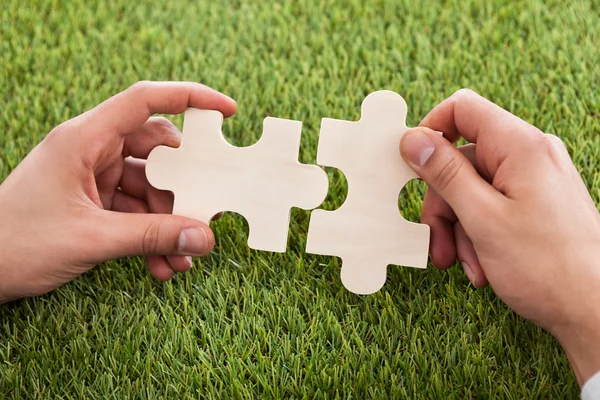 Hands Connecting Two Puzzle Pieces — Stock Photo, Image