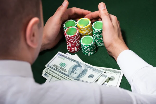 Ember scooping fel dollárt, és a póker zseton — Stock Fotó