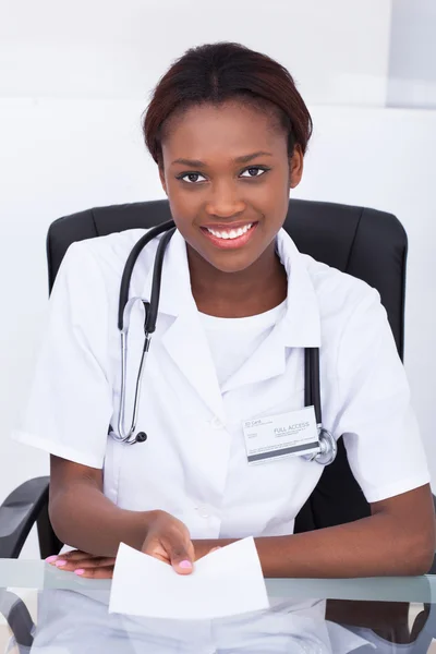 Médecin féminin donnant du papier sur ordonnance au bureau — Photo