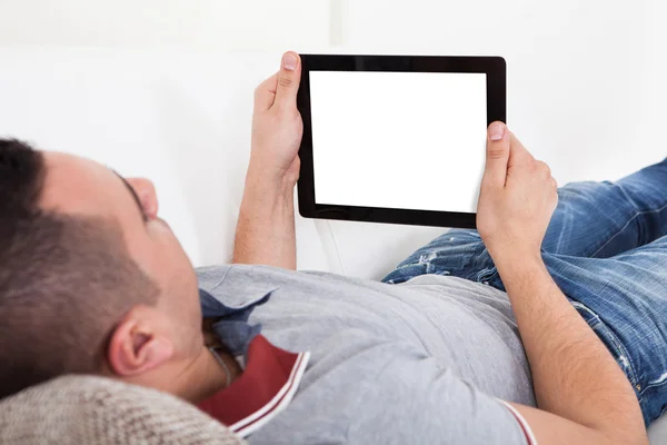 Człowiek za pomocą cyfrowego tabletu na kanapie — Zdjęcie stockowe