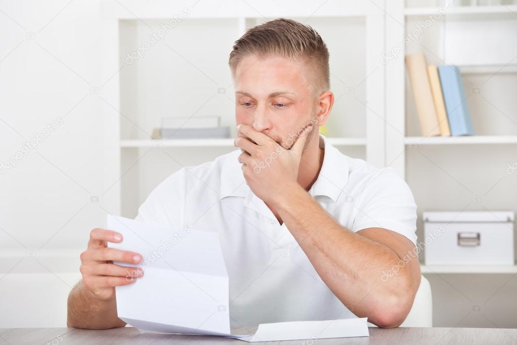 Businessman reacting in shock to a letter