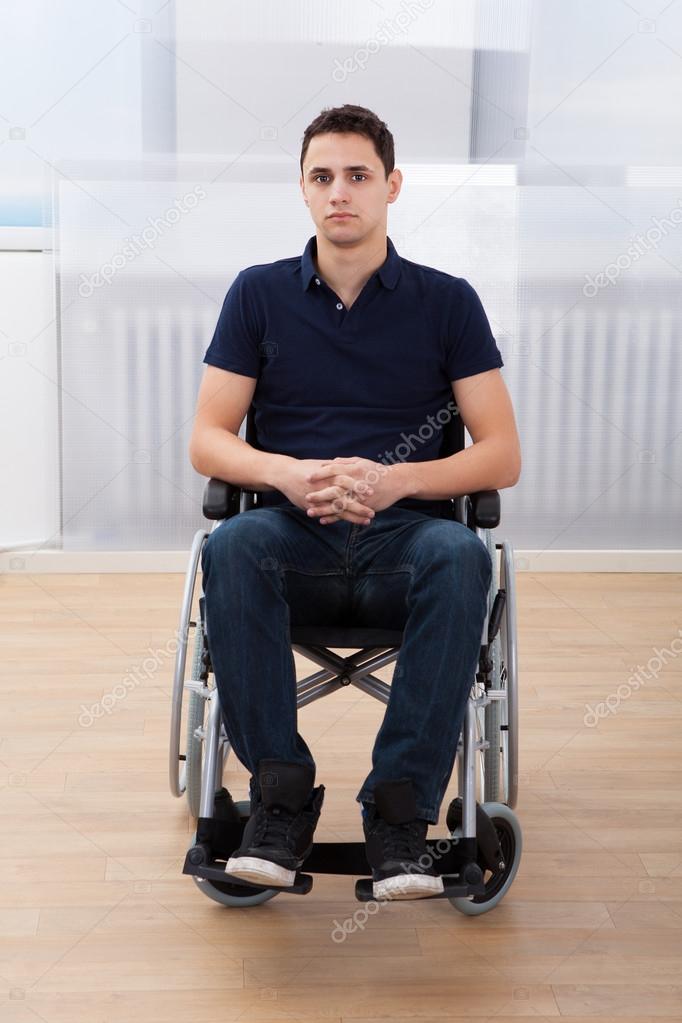 Handicapped Man Sitting On Wheelchair At Home