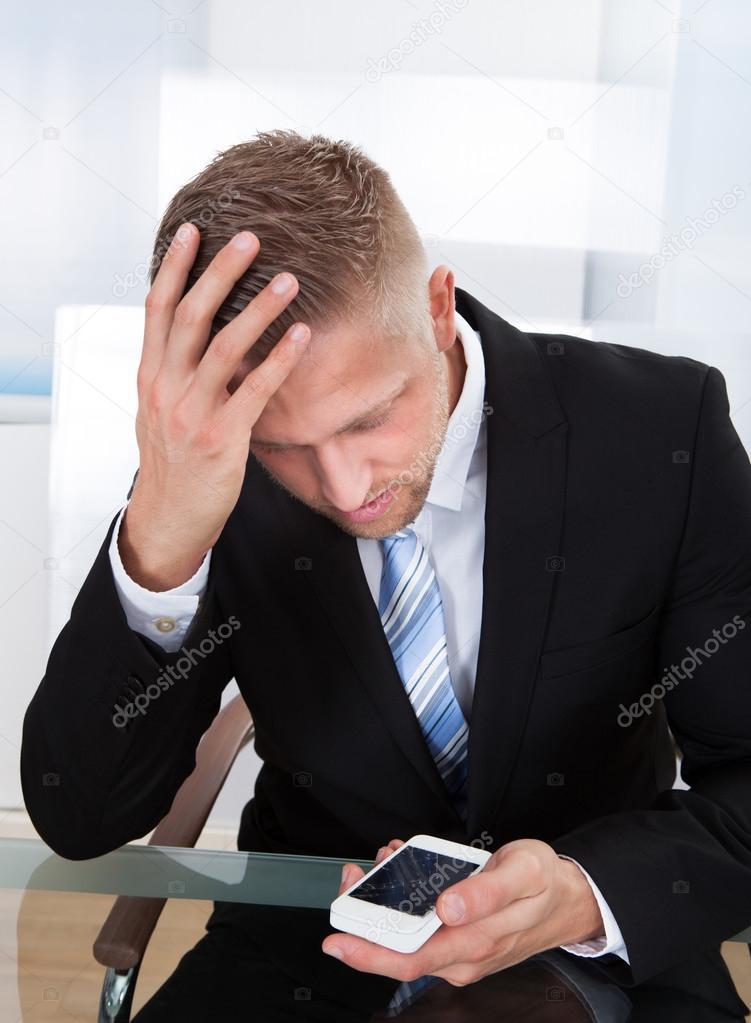 Worried businessman checking a mobile message