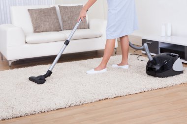 Maid Cleaning Carpet With Vacuum Cleaner clipart
