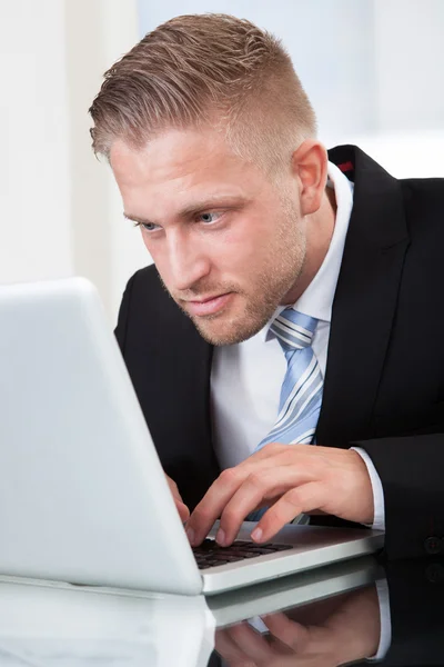 Affärsman framåtlutad på hans laptop skärm — Stockfoto
