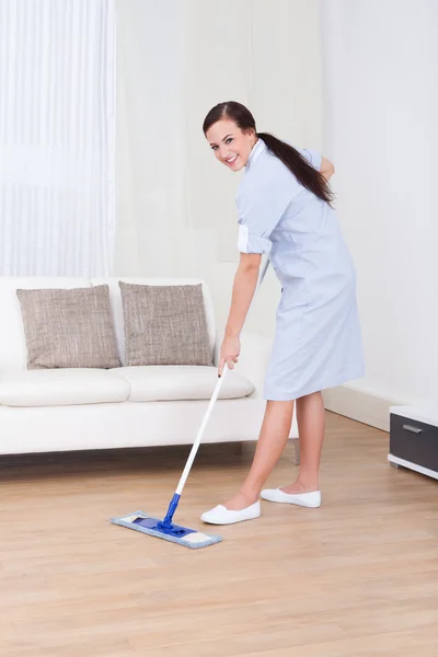 Meid schoonmaak verdieping met mop — Stockfoto