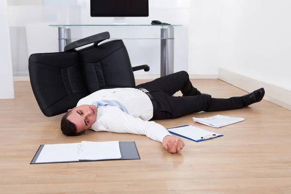 Empresário caído da cadeira do escritório — Fotografia de Stock