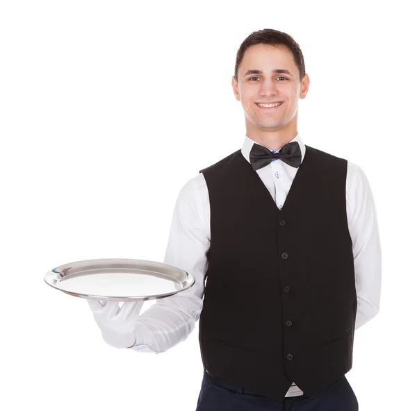 Уверенный официант держит пустой поднос — стоковое фото