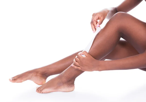 Femme épilation jambes sur fond blanc — Photo