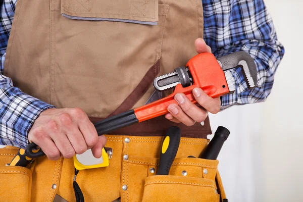 Reparador segurando a chave de tubulação — Fotografia de Stock