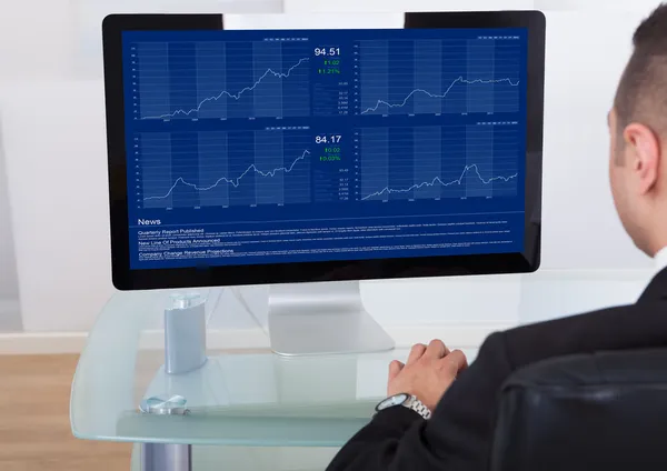 Empresário verificando o mercado de ações no computador — Fotografia de Stock