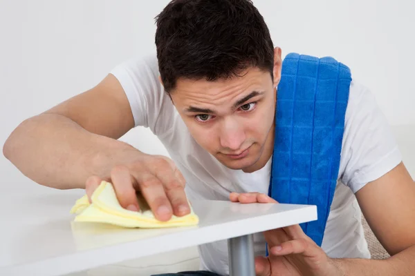 Mann putzt Tisch mit Serviette zu Hause — Stockfoto