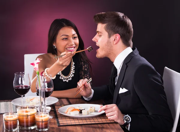 Женщина кормит мужчину в ресторане — стоковое фото