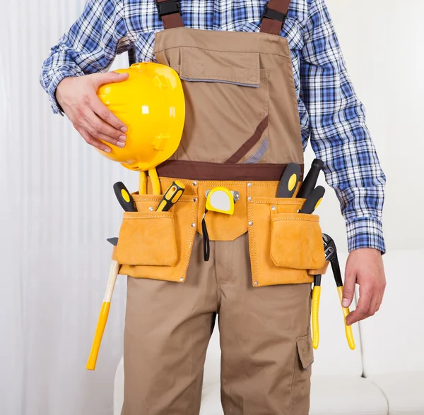 Reparaturarbeiter hält Bohrmaschine im Wohnzimmer — Stockfoto