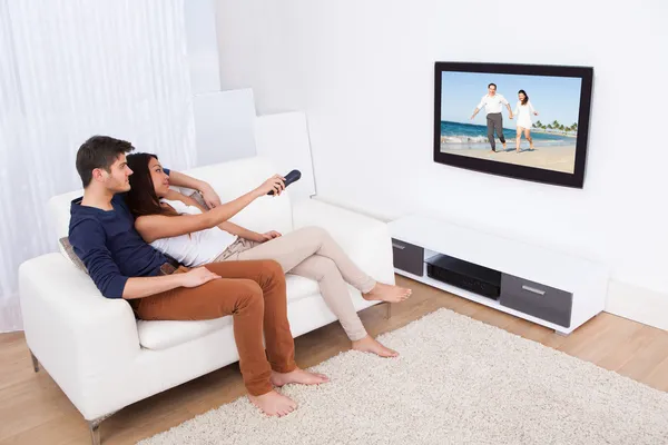 Coppia guardando la TV in salotto — Foto Stock