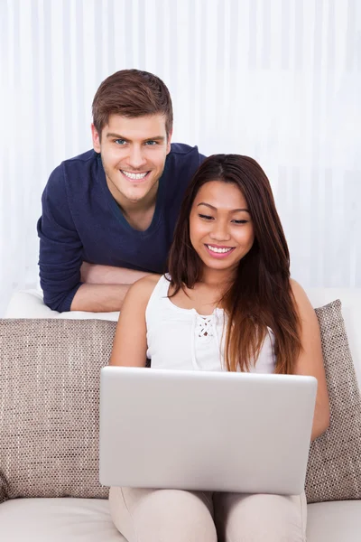 Couple avec ordinateur portable dans le salon — Photo