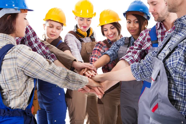 Diverso grupo de trabajadores de la construcción que apilan las manos — Foto de Stock
