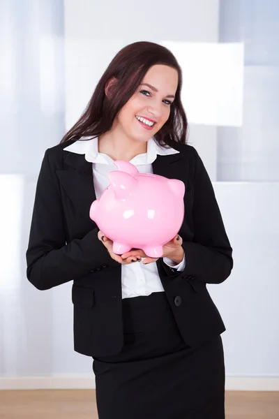 Empresária segurando banco porquinho — Fotografia de Stock