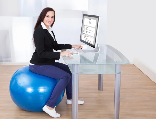 Businesswoman Using Computer While Sitting On Pilates Ball — Stock Photo, Image